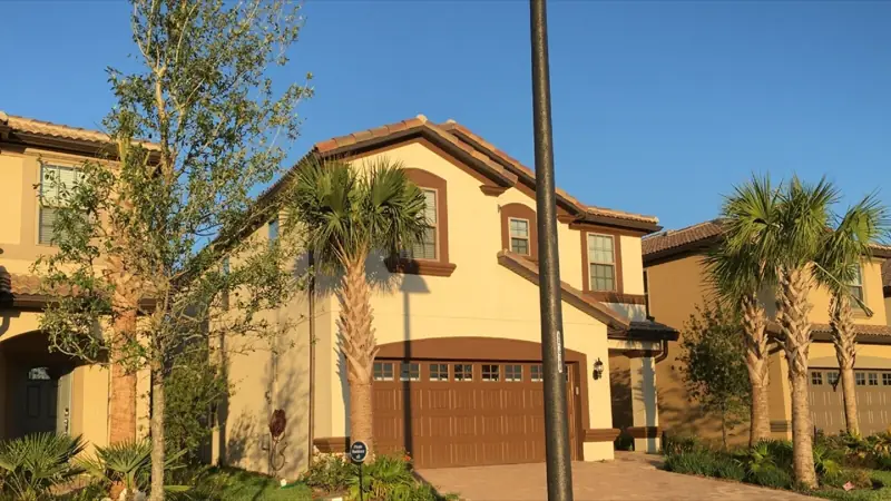 Exterior – A two-story house with a garage, surrounded by palm trees and a well-maintained lawn.